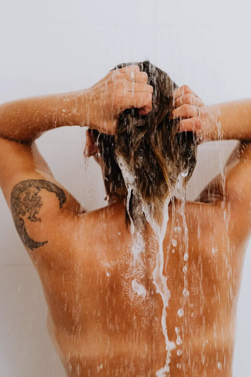 Cabelo sendo enxaguado no banho, de costas